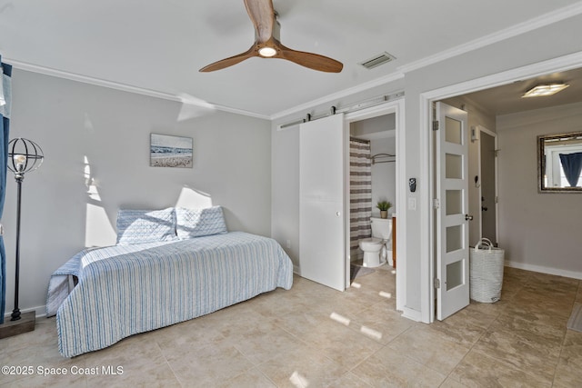 bedroom featuring ornamental molding, a barn door, ceiling fan, and ensuite bathroom