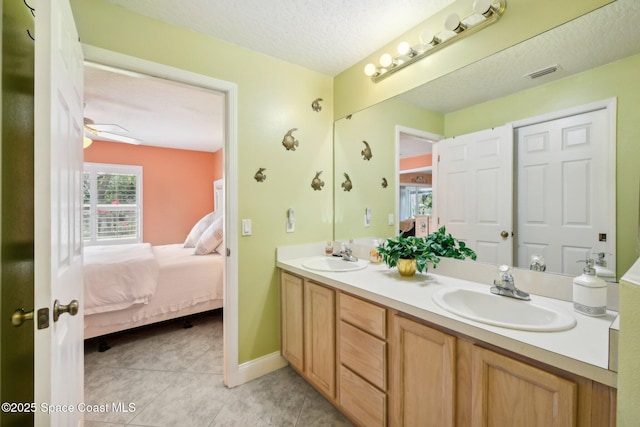 bathroom with tile patterned flooring, vanity, a textured ceiling, and ceiling fan