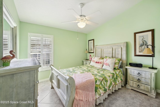 bedroom with lofted ceiling, light tile patterned floors, and ceiling fan