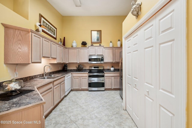 kitchen featuring stainless steel appliances, light tile patterned flooring, sink, and light brown cabinets