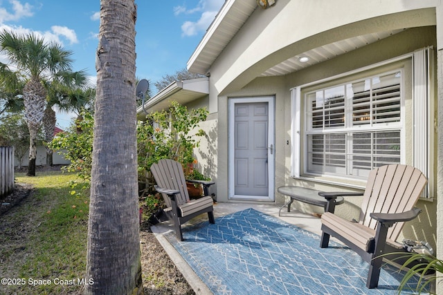 view of exterior entry with a patio