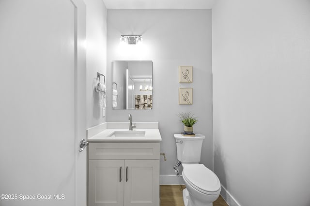 bathroom with hardwood / wood-style flooring, vanity, and toilet