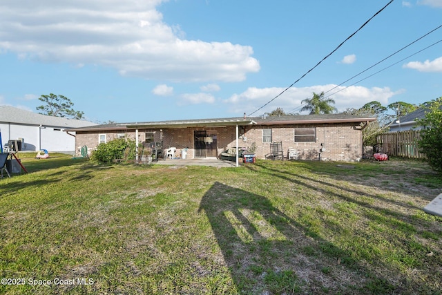 back of house with a lawn and a patio area