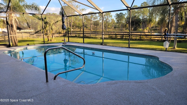 view of pool featuring a patio area, a yard, and glass enclosure