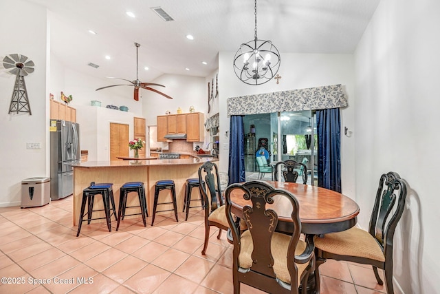 tiled dining room featuring high vaulted ceiling and ceiling fan with notable chandelier