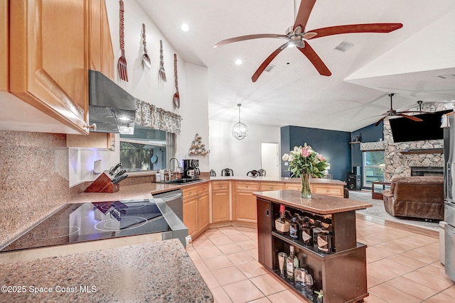 kitchen featuring lofted ceiling, sink, light tile patterned flooring, light brown cabinets, and range