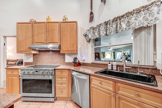 kitchen with stainless steel appliances, light stone countertops, decorative backsplash, light brown cabinets, and sink