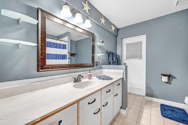 bathroom with a textured ceiling, toilet, vanity, and tile patterned flooring