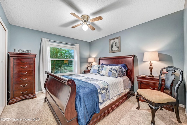 carpeted bedroom with ceiling fan and a textured ceiling