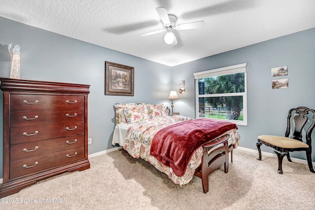 carpeted bedroom featuring ceiling fan and a textured ceiling