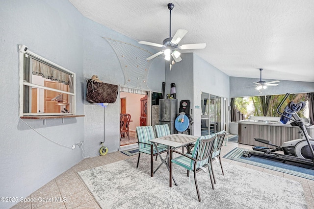 dining area featuring ceiling fan, tile patterned flooring, a textured ceiling, and lofted ceiling