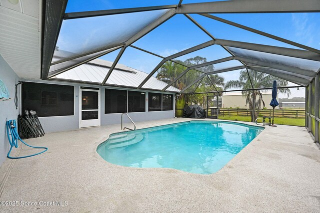 view of pool featuring grilling area, glass enclosure, and a patio area