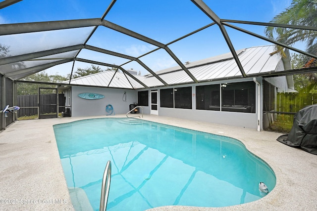 view of pool with glass enclosure and a patio area