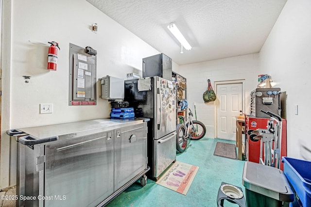 kitchen featuring stainless steel refrigerator and a textured ceiling