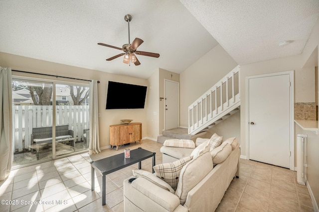 living room featuring light tile patterned floors, a textured ceiling, and ceiling fan