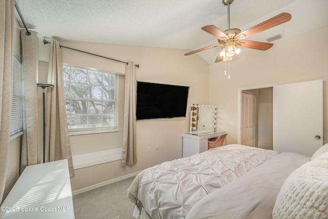 carpeted bedroom featuring ceiling fan, lofted ceiling, a closet, and a textured ceiling