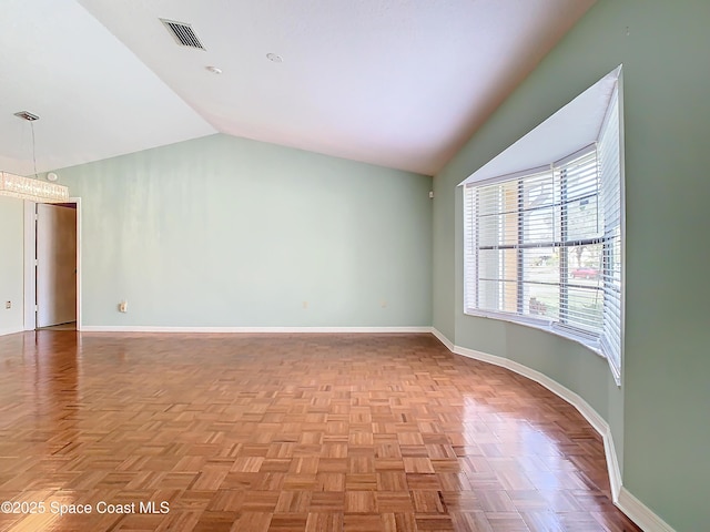 unfurnished room with light parquet floors and vaulted ceiling