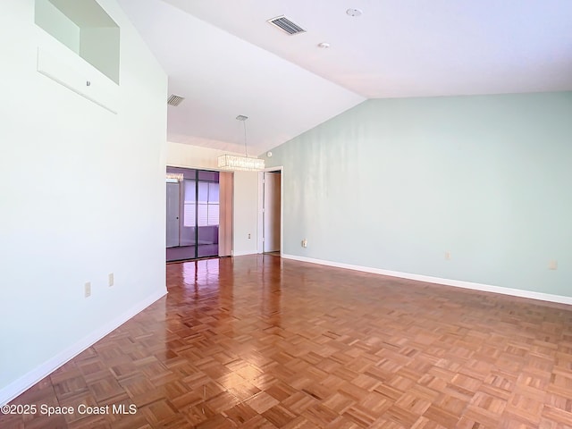 spare room with lofted ceiling, a notable chandelier, and parquet flooring