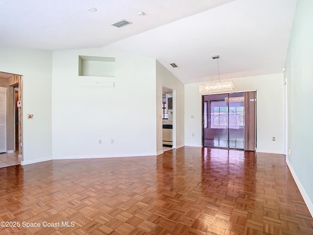 empty room with parquet flooring, high vaulted ceiling, and a chandelier