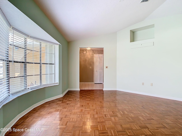 unfurnished room with light parquet floors and lofted ceiling