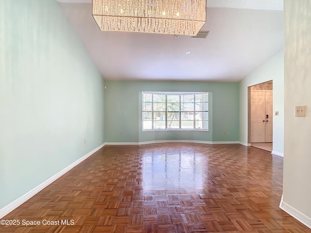 empty room with high vaulted ceiling and dark parquet floors