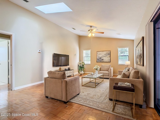 living room with lofted ceiling with skylight, light parquet flooring, and ceiling fan