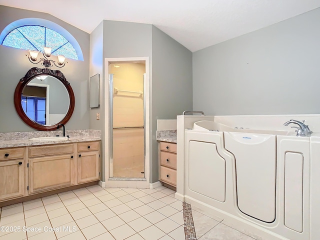 bathroom with tile patterned floors, vanity, vaulted ceiling, and a notable chandelier