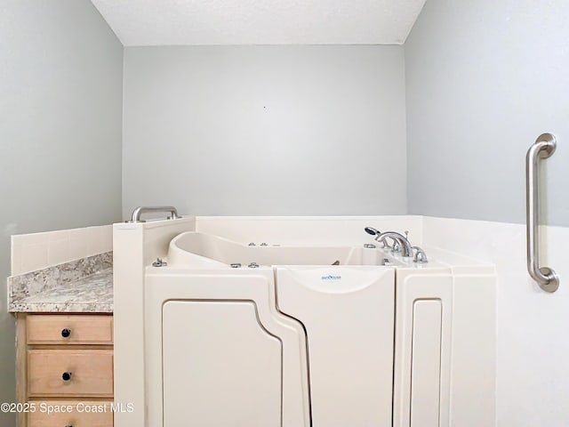 bathroom featuring a washtub and a textured ceiling