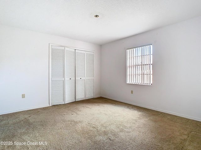 unfurnished bedroom with carpet and a closet