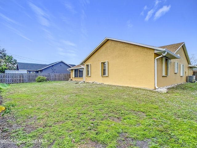 rear view of house featuring a yard and central AC