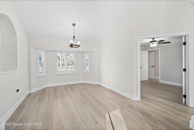 spare room with vaulted ceiling, a chandelier, and light wood-type flooring