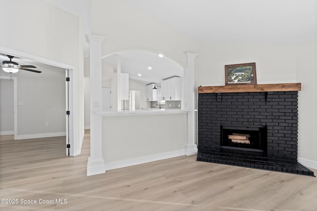 unfurnished living room featuring lofted ceiling, a fireplace, and light wood-type flooring