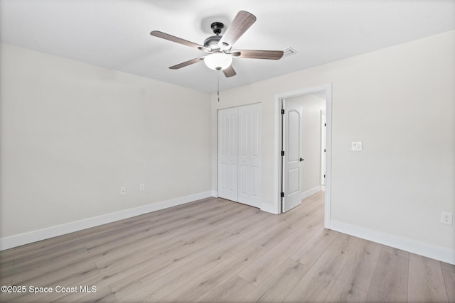 unfurnished bedroom featuring ceiling fan, light wood-type flooring, and a closet