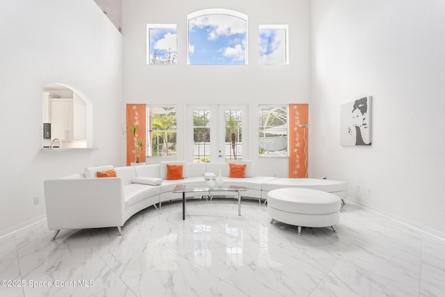 living room with french doors and a towering ceiling