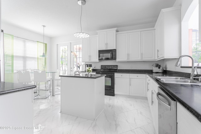 kitchen featuring decorative light fixtures, white cabinetry, sink, and black appliances