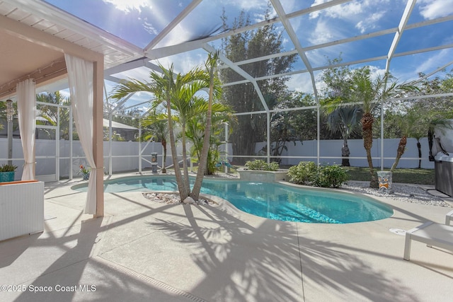 view of swimming pool with glass enclosure and a patio area