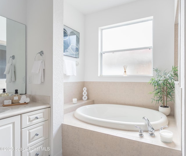 bathroom featuring vanity and tiled tub