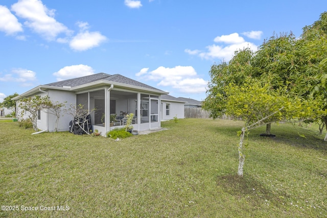 back of house featuring a sunroom and a lawn