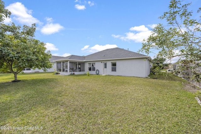 back of property with a yard and a sunroom