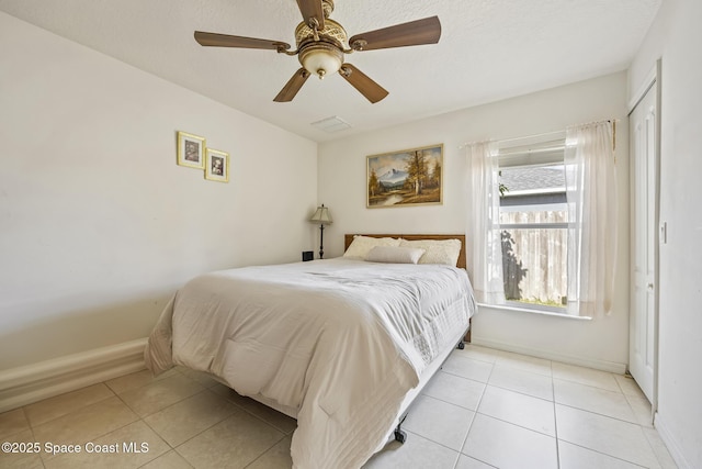 tiled bedroom featuring ceiling fan