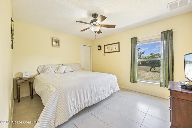 tiled bedroom featuring ceiling fan and a closet