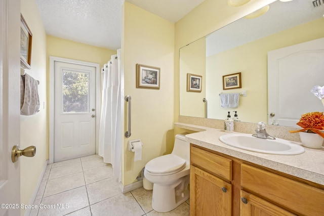 bathroom with vanity, toilet, tile patterned flooring, and a textured ceiling