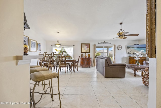 tiled living room with a textured ceiling and ceiling fan