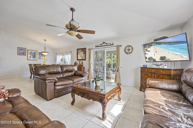 tiled living room featuring ceiling fan, lofted ceiling, and a textured ceiling