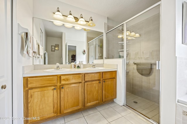 bathroom featuring tile patterned floors, vanity, an enclosed shower, and a textured ceiling