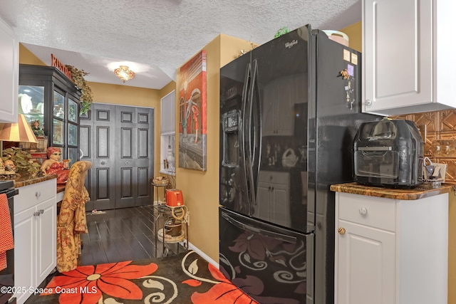 kitchen with white cabinetry, black refrigerator with ice dispenser, decorative backsplash, and a textured ceiling