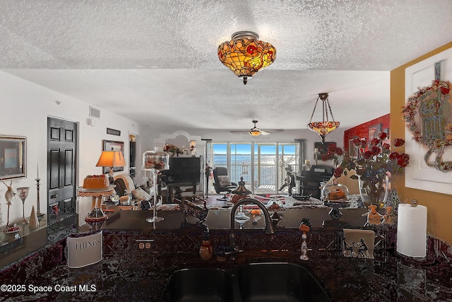 interior space with sink, decorative light fixtures, a textured ceiling, and ceiling fan