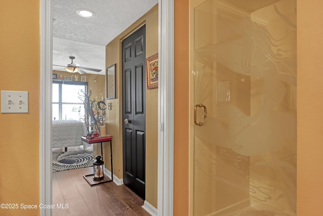 hallway featuring dark hardwood / wood-style floors and a textured ceiling