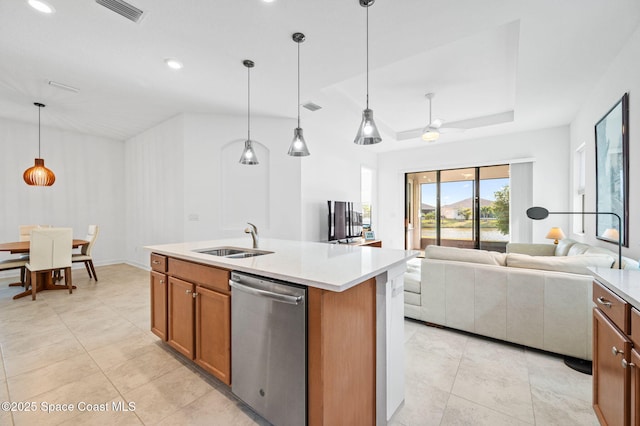 kitchen with sink, dishwasher, a kitchen island with sink, hanging light fixtures, and a raised ceiling