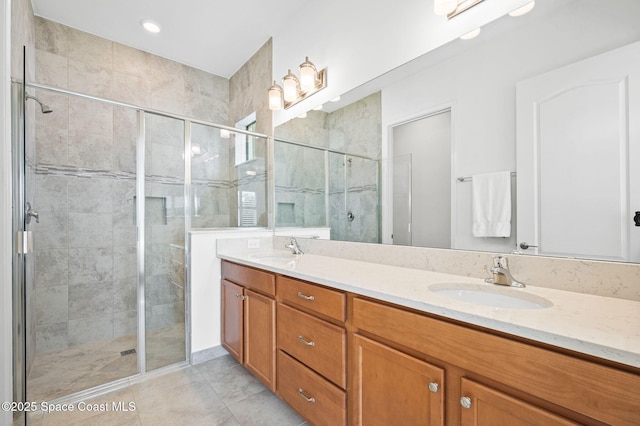 bathroom with a shower with door, vanity, and tile patterned flooring